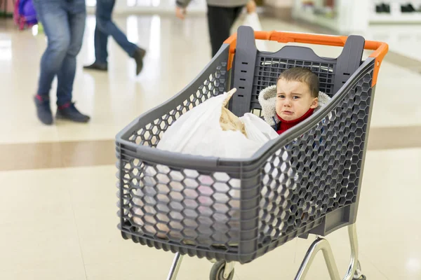 Малыш плачет в тележке в торговом центре — стоковое фото
