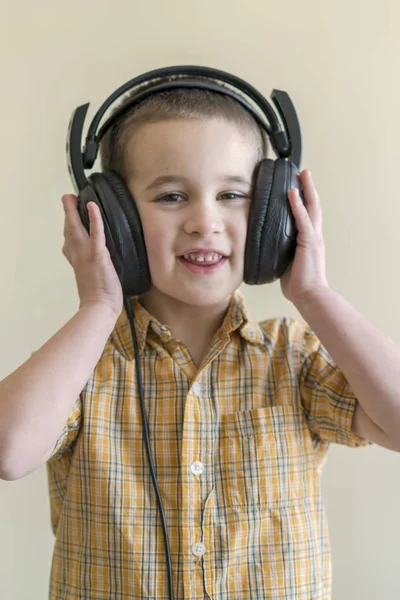 Mały chłopiec słuchanie muzyki w duże słuchawki Czarny — Zdjęcie stockowe