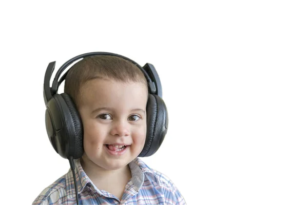 Piękne chłopca w duże słuchawki. Chłopiec w plaid shirt słuchania muzyki. Na białym tle — Zdjęcie stockowe