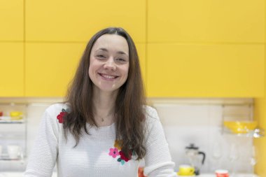 Yeni modern bir mutfak mutlu bir genç kadın. Mutlu genç kadın uzun saçlı