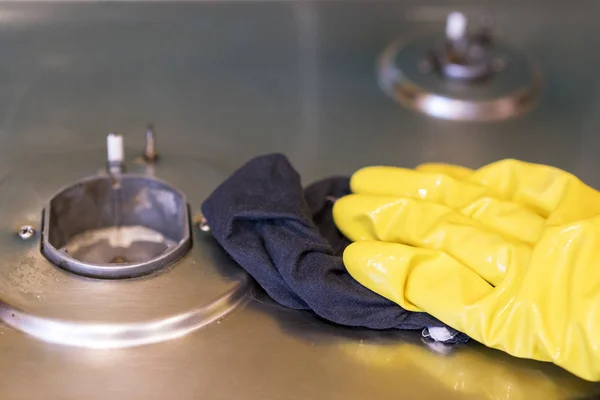 Een vrouw in beschermende handschoenen wast de gaskachel — Stockfoto