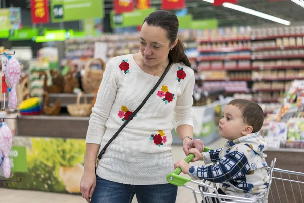 एक सुपरमार्केट में एक छोटे बेटे के साथ माँ — स्टॉक फ़ोटो, इमेज