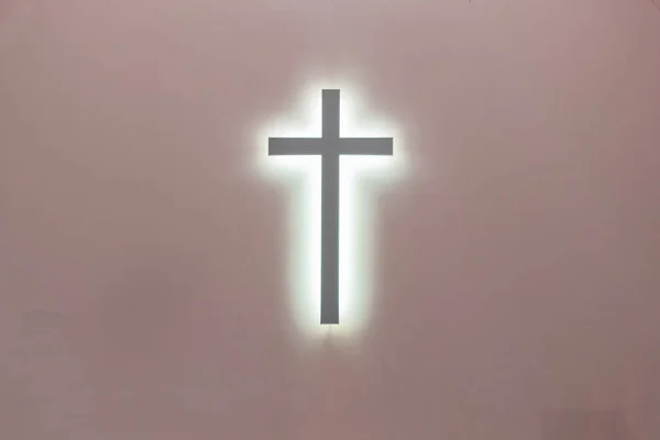 ピンクの背景にキリスト教の十字。キリスト教のシンボルです。キリストの磔刑 — ストック写真