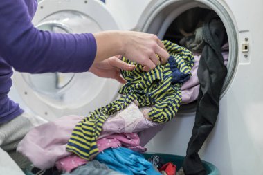 Yıkama döngüsünü hazırlıyorum. Çamaşır makinesi, eller ve elbiseler.