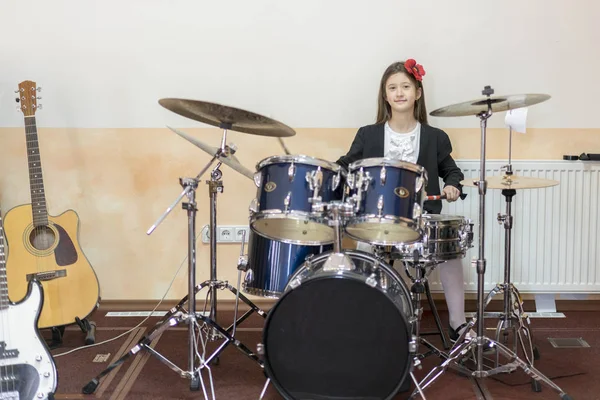 Genç beyaz genç kız bateri çalıyor. davul seti oynayan kız.