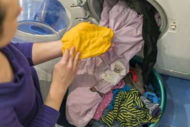 Yıkama döngüsünü hazırlıyorum. Çamaşır makinesi, eller ve elbiseler..