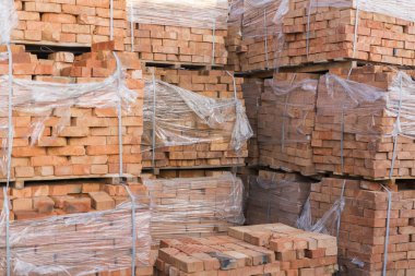 Clay bricks stored for building construction. Industrial production of bricks.