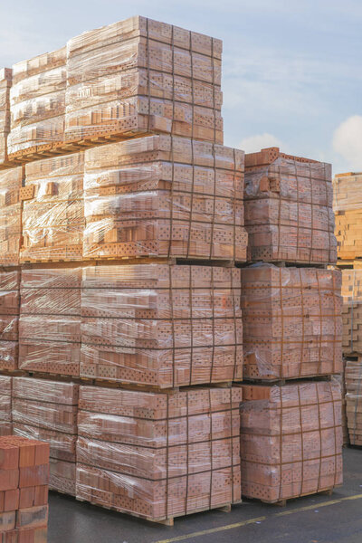 Several pallets with bricks stacked on top of each other in depot. Industrial production of bricks.  