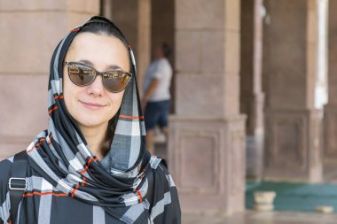 Woman in arabic clothes near the mosque. Islamic faith concept.