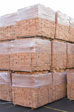 Several pallets with bricks stacked on top of each other in depot. Industrial production of bricks.  