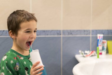 Çocuk evde diş yıkama makinesiyle diş yıkıyor. Diş bakımı konsepti. Oral Bakım Konsepti.