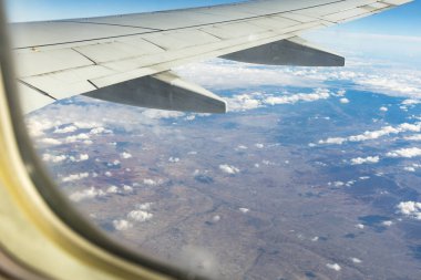 Clouds and sky seen through window of aircraft. Window of plane.
