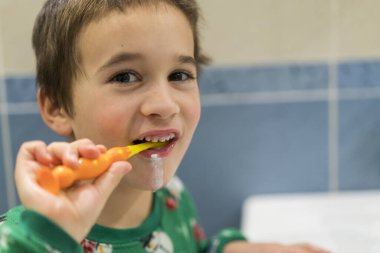 Happy little boy brushing teeth. Oral hygiene concept. Close up.