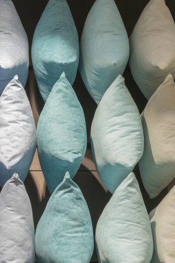 Çok renkli yastıkların arka planı. Yastıklardan yapılmış yaratıcı bir arka plan. Mor, mavi, bej, gri yastıklar. 