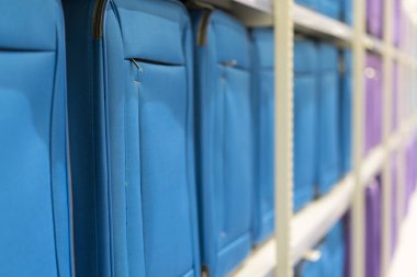 Blue and purple suitcases on shelf in store. Travel concept.