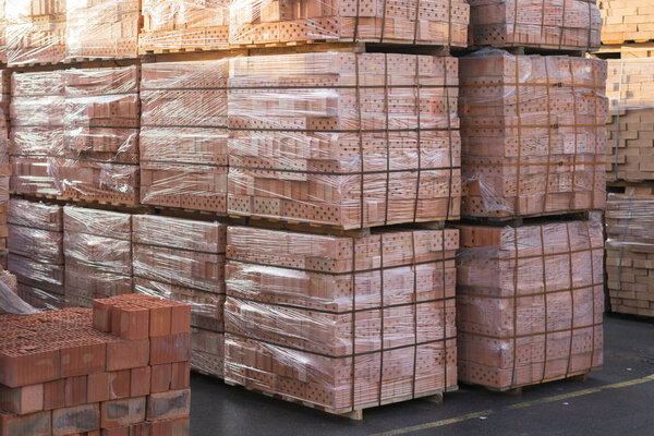 Clay bricks stored for building construction. Industrial production of bricks. 