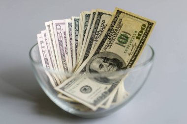 Dolarlar cam bir vazoda. Bir şişede yığınla dolar. Amerikan dolarlarıyla kavanozda para biriktiriyorum. Para biriktirme kavramı.