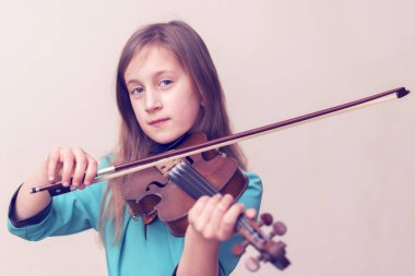 küçük kız evde keman çalıyor.  