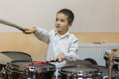 Davul çalan beyaz gömlekli çocuk..