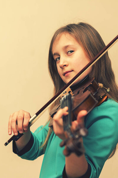 cute girl in a blue dress with a violin. toned. vertical photo. toned.