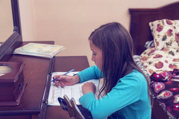 Hausaufgabenbetreuung. Schulmädchen lernt Hausaufgaben-Mathe während ihres Online-Unterrichts zu Hause, soziale Distanz während der Quarantäne, Selbstisolierung, Online-Bildungskonzept, Heimschüler. gemildert — Stockfoto