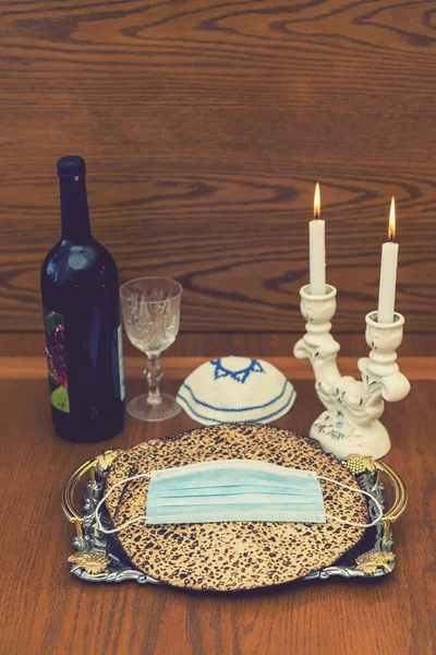 Пасха Корона. Пилова маска, пляшка вина і маца - традиційна єврейська їжа на Пасху. Маленький пасхальний седер в епоху Corona Virus. Через карантин Ковід-19 — стокове фото