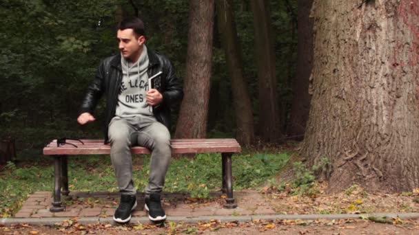 Man reading a book sitting on the bench — Stock Video