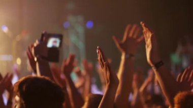 Kız kalabalık konser kalabalığın ortasında duran ve cep telefonu onun elinde tutan smartphone.girl video çekimleri. 