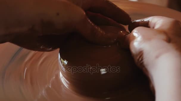 Creación de una maceta de arcillo.Gonchar.Potter.A turner.Workshop de arcilla. Arcilla en el dispositivo.Master.Hands trabajando en la rueda de cerámica, la forma de una olla de arcilla — Vídeo de stock