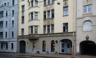 Riga 'nın merkez caddelerinden birinde ulusal romantizm tarzında bir konut kapısı olan ön cephenin bir parçası.