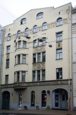 Riga 'nın merkez caddelerinden birinde ulusal romantizm tarzında bir konut kapısı olan ön cephenin bir parçası.