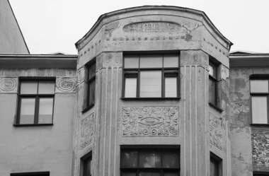 Riga 'nın merkez caddelerinden birinde ulusal romantizm tarzında bir konut kapısı olan ön cephenin bir parçası.