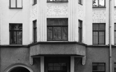 Riga 'nın merkez caddelerinden birinde ulusal romantizm tarzında bir konut kapısı olan ön cephenin bir parçası.