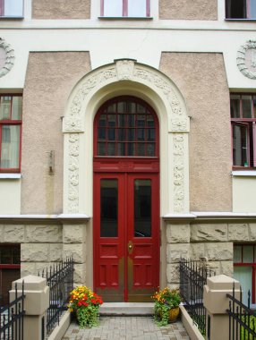 Riga 'nın merkez caddelerinden birinde ulusal romantizm tarzında bir konut kapısı olan ön cephenin bir parçası.