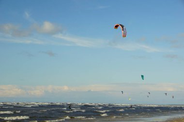 Yaz güneşli bir gün ve Riga Körfezi dalgalarında uçurtma sörfü müsabakaları