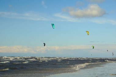 Yaz güneşli bir gün ve Riga Körfezi dalgalarında uçurtma sörfü müsabakaları