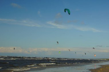 Yaz güneşli bir gün ve Riga Körfezi dalgalarında uçurtma sörfü müsabakaları
