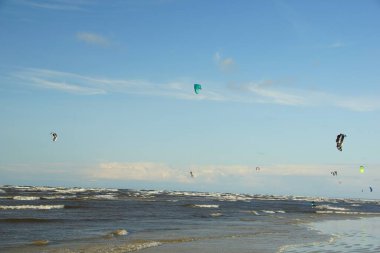 Yaz güneşli bir gün ve Riga Körfezi dalgalarında uçurtma sörfü müsabakaları