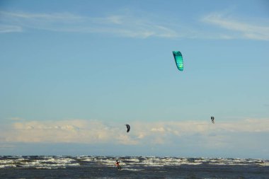 Yaz güneşli bir gün ve Riga Körfezi dalgalarında uçurtma sörfü müsabakaları