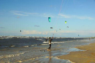 Yaz güneşli bir gün ve Riga Körfezi dalgalarında uçurtma sörfü müsabakaları