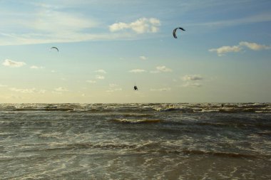 Yaz güneşli bir gün ve Riga Körfezi dalgalarında uçurtma sörfü müsabakaları