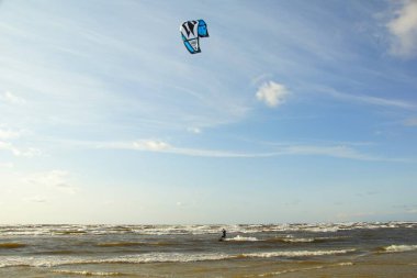 Yaz güneşli bir gün ve Riga Körfezi dalgalarında uçurtma sörfü müsabakaları