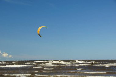 Yaz güneşli bir gün ve Riga Körfezi dalgalarında uçurtma sörfü müsabakaları