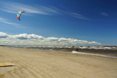 Yaz güneşli bir gün ve Riga Körfezi dalgalarında uçurtma sörfü müsabakaları