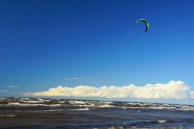 Yaz güneşli bir gün ve Riga Körfezi dalgalarında uçurtma sörfü müsabakaları