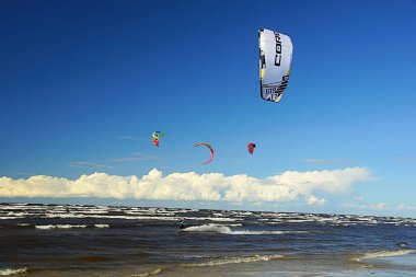 Yaz güneşli bir gün ve Riga Körfezi dalgalarında uçurtma sörfü müsabakaları