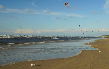 Yaz güneşli bir gün ve Riga Körfezi dalgalarında uçurtma sörfü müsabakaları