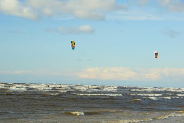 Yaz güneşli bir gün ve Riga Körfezi dalgalarında uçurtma sörfü müsabakaları
