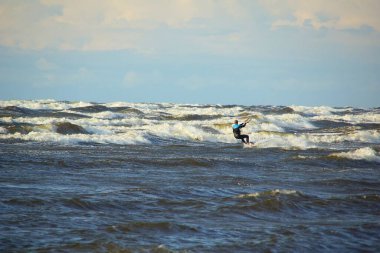 Yaz güneşli bir gün ve Riga Körfezi dalgalarında uçurtma sörfü müsabakaları