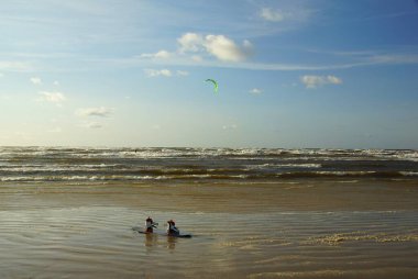 Yaz güneşli bir gün ve Riga Körfezi dalgalarında uçurtma sörfü müsabakaları
